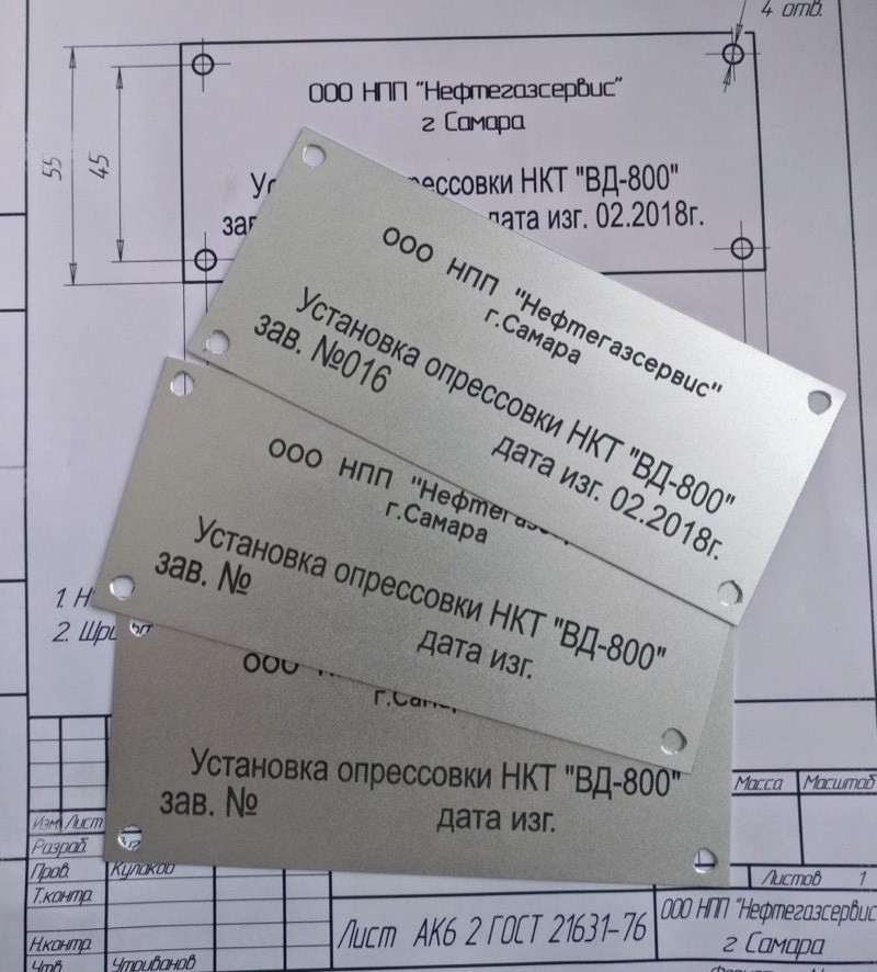 Шильды из анодированного алюминия с чёрной лазерной гравировкой лежат на чертеже заказчика